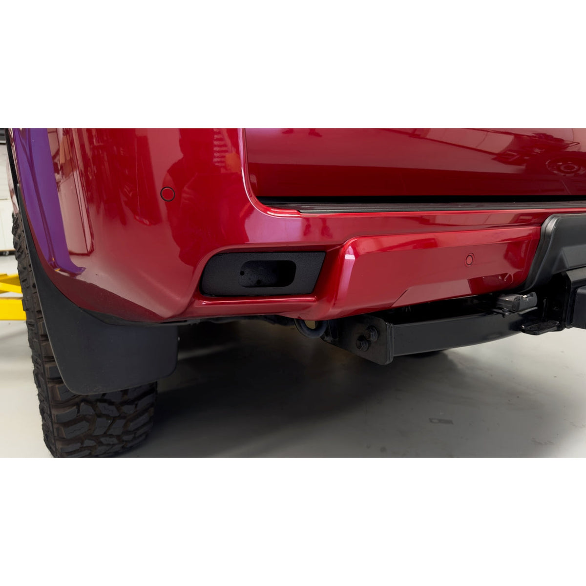 150 Prado Rear Work Lights Bracket installed in red Prado rear bumper showing factory-look fit